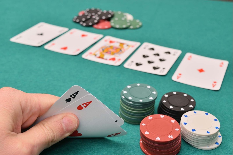 zmogus tikrina savo pokerio kortas